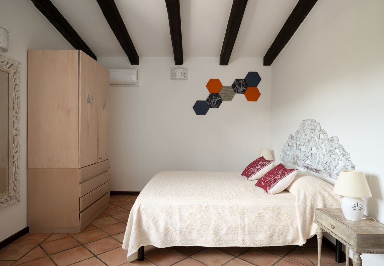Villa Kiki - chambre avec hauts plafonds et poutres apparentes, maison de vacances en Sardaigne